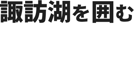 諏訪湖を囲む家々、背後に連なるアルプス。